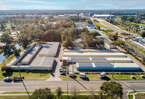 Aerial view of self storage facility near main road with surrounding neighborhood and trees